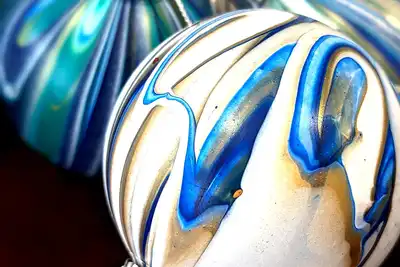 Close-up of artistically painted blue, white, and gold holiday ornaments, perfect for teambuilding art workshops aimed at enhancing creativity and collaboration among team members.