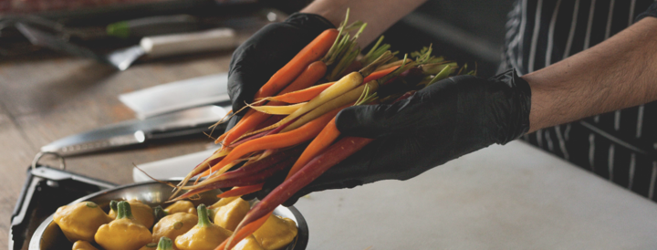 Chef preparing colorful vegetables for a team-building cooking event, featuring vibrant carrots and yellow squash, perfect for HR professionals seeking engaging culinary experiences.
